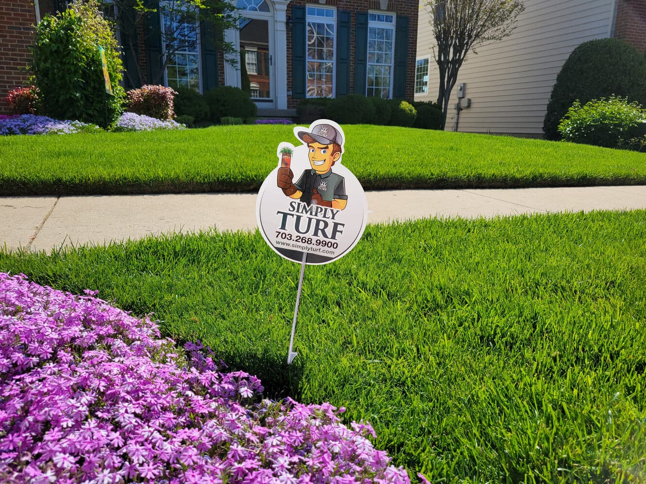 A healthy green lawn with a Simply Turf yard sign